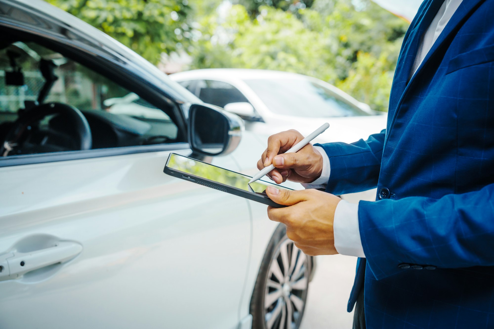 businessman in suit and car auto insurance agent assess car damage, discussing deductible, claims